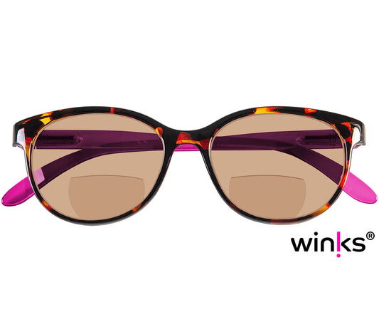 Female model wearing Sienna (Purple) cat eye shaped bifocal reading sunglasses with tortoiseshell frames and bright pink temples. Large oval lenses with a brown tint.