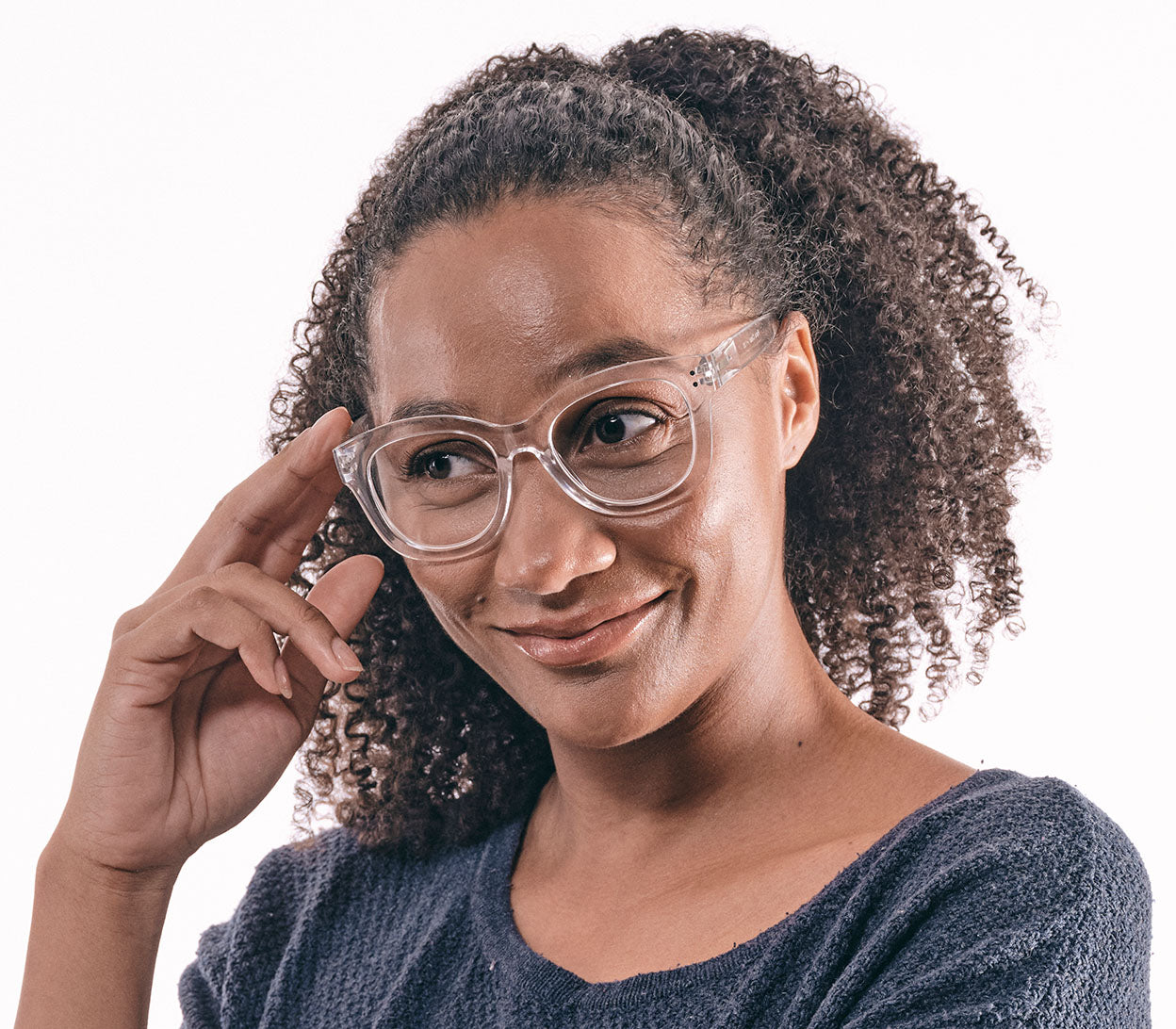 Female model wearing Paris (Clear) oversized, cat eye shaped women's reading glasses with a translucent frame and rivet details.