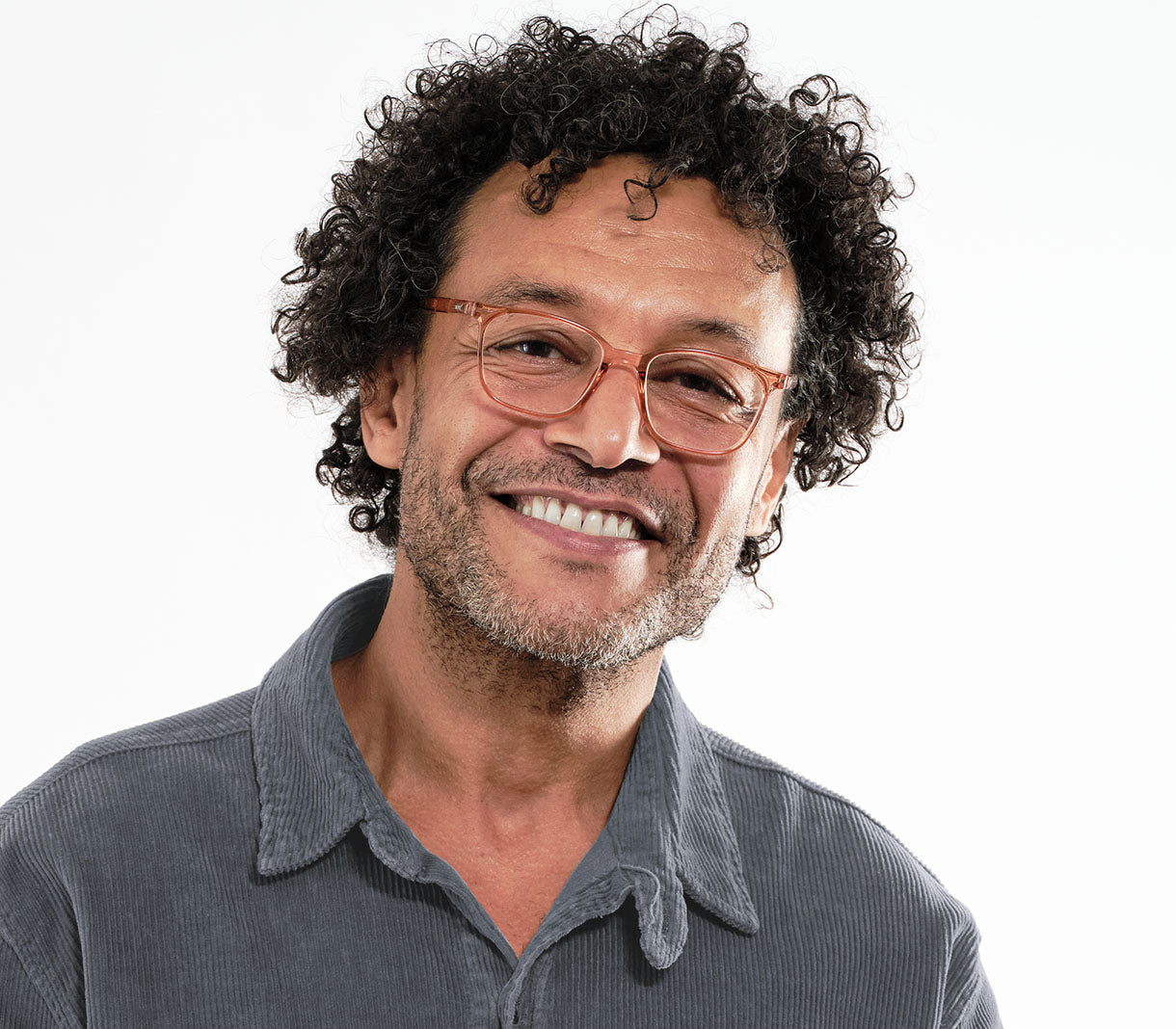 Male model wearing Artist (Orange) unisex reading glasses with orange frames and oval lenses.
