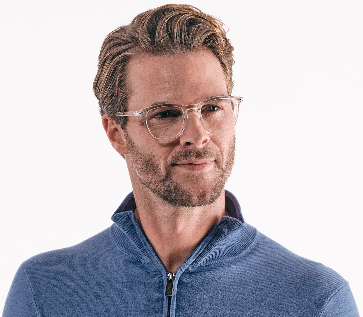 Male model wearing Scholar (Clear) retro unisex reading glasses with large oval shaped lenses, a slender clear frame and rivet details.