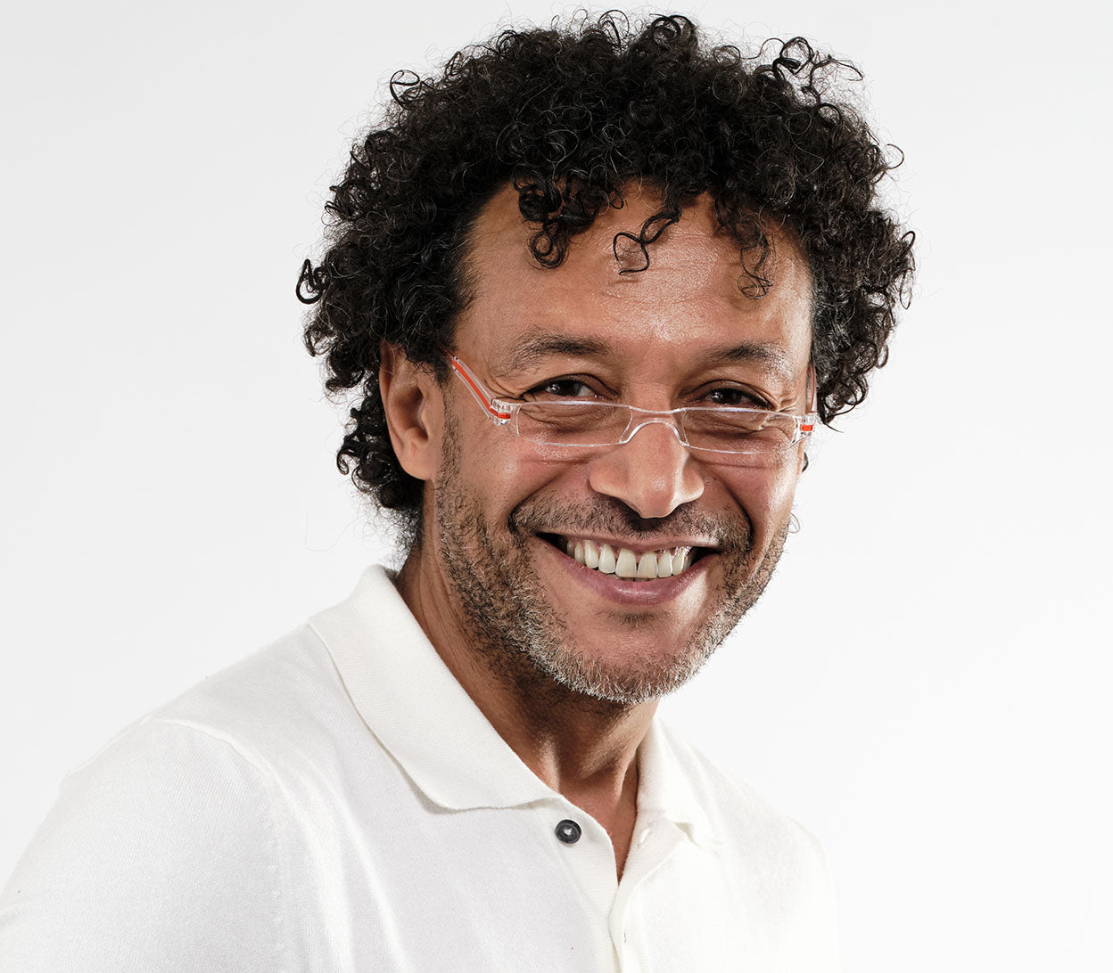 Male model wearing Soda (Orange) seek, compact and ultra lightweight reading glasses with clear frames and orange detailed temples.