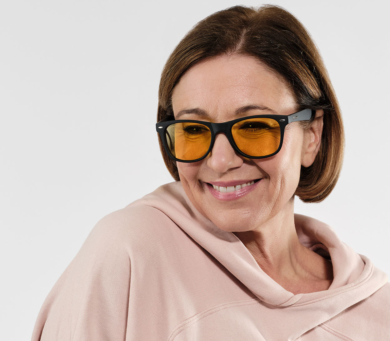 Female model wearing Grid (Black) classic wayfarer shaped night driving glasses.