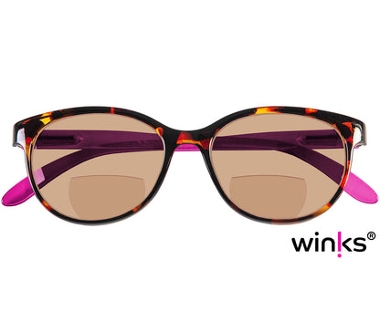 Female model wearing Sienna (Purple) cat eye shaped bifocal reading sunglasses with tortoiseshell frames and bright pink temples. Large oval lenses with a brown tint.