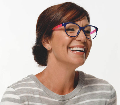 Female model wearing Angel (Blue) womens cat eye style reading glasses with blue frames and pink arms.