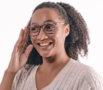 Female model wearing Lima (Multi-coloured) classic style, unisex reading glasses with oval lenses. Translucent, delicate floral patterned frames and gold arms.
