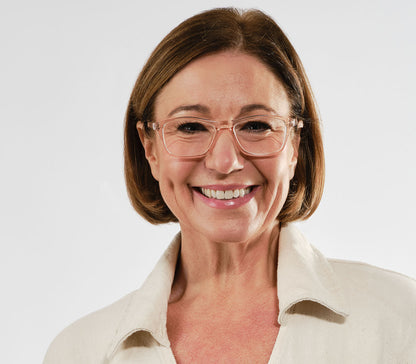 Female model wearing Echo (Orange) classic shaped unisex reading glasses with a pale orange, translucent frame.