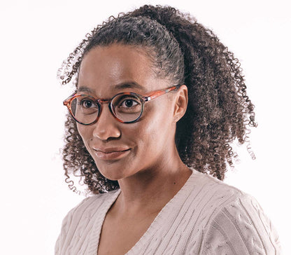 Female model wearing Oskar (Multi-coloured) unisex reading glasses with large round lenses and a glossy multi-coloured frame.