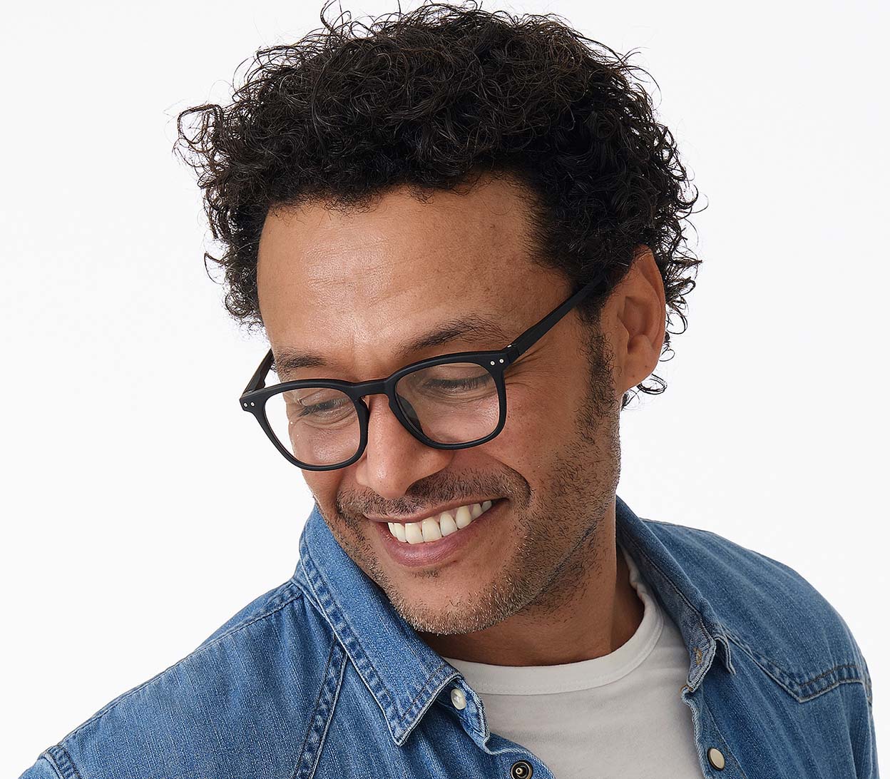 Male model wearing Scholar (Black) retro unisex reading glasses with large oval shaped lenses, slender black frames and rivet details.