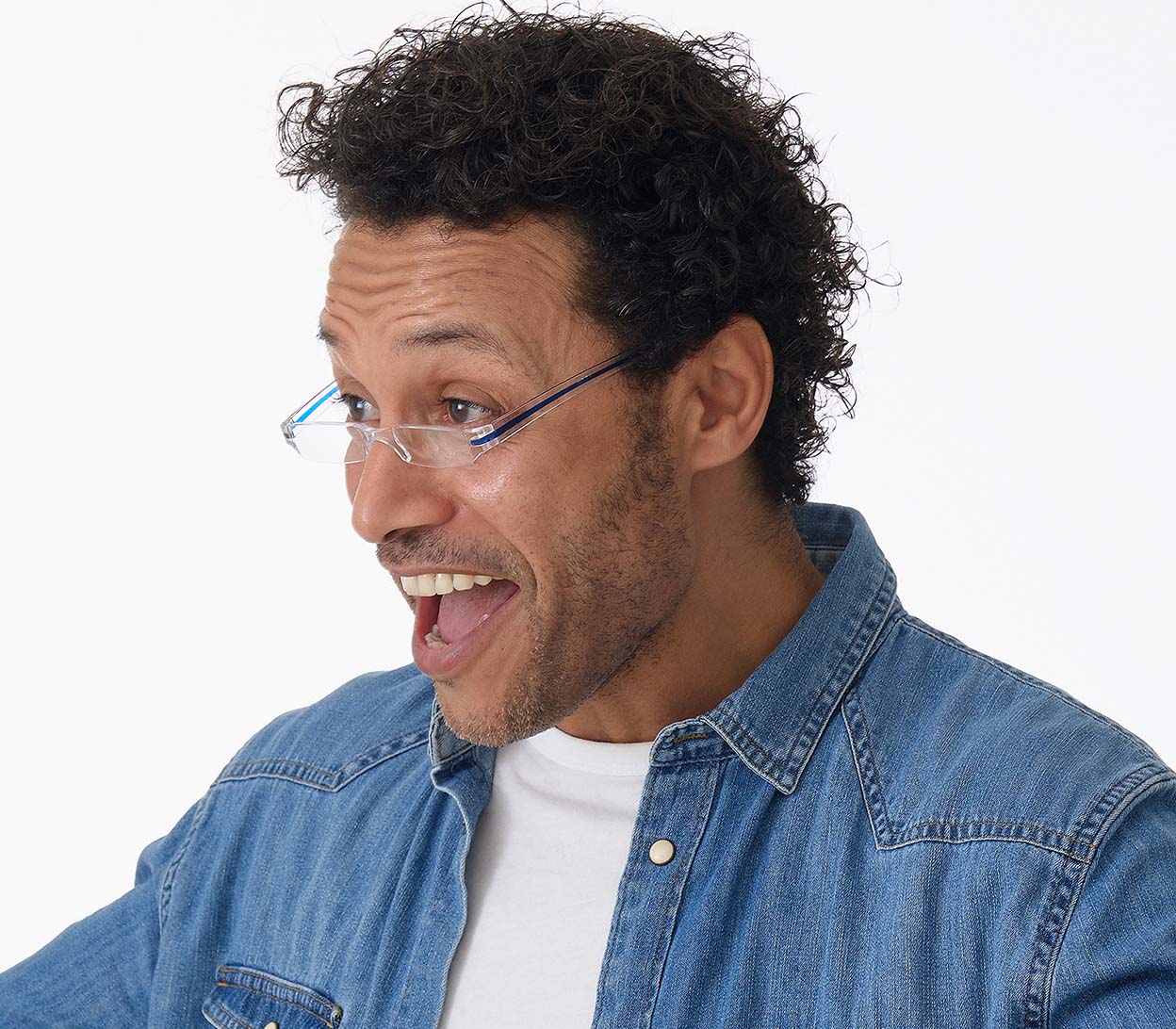 Male model wearing Soda (Blue) seek, compact and ultra lightweight reading glasses with clear frames and blue detailed temples.