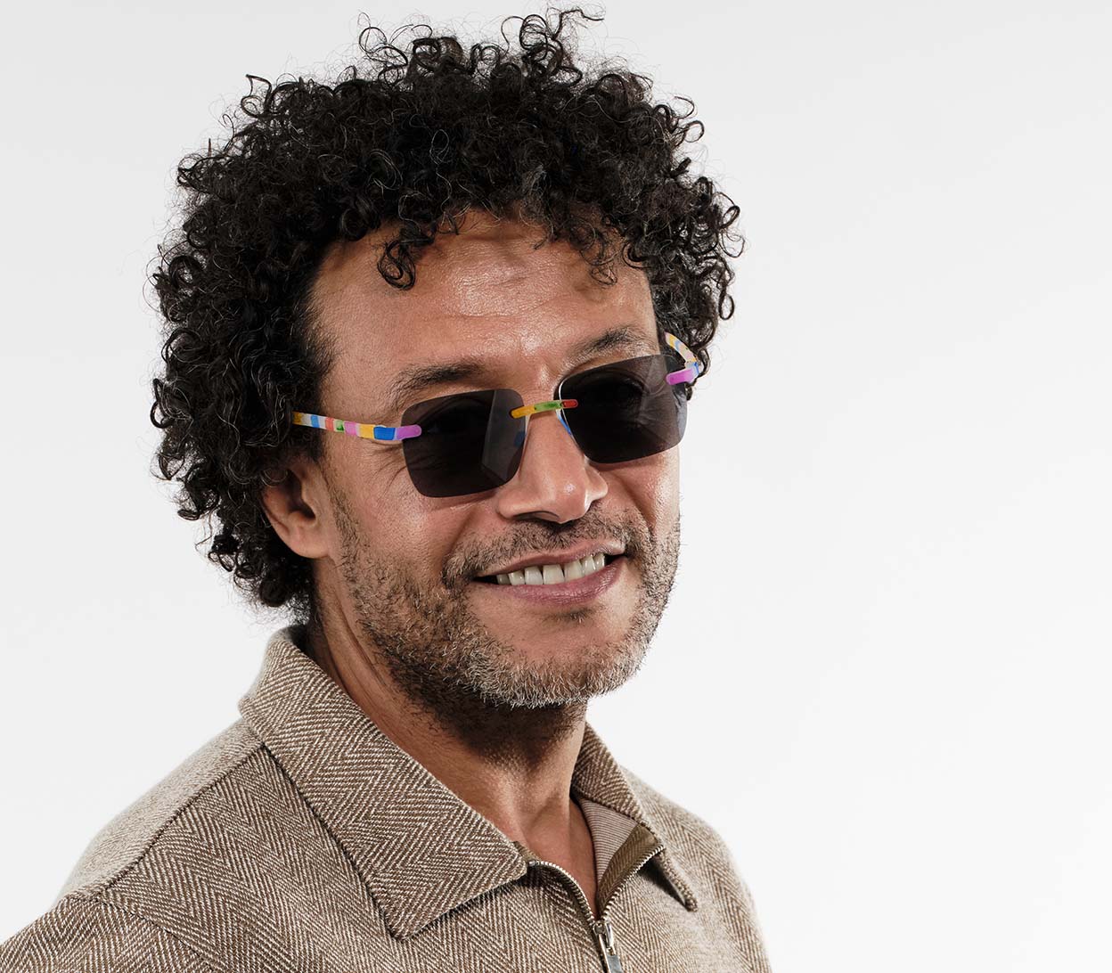 Male model wearing Jelli Sun (Multi-coloured) unisex sun reading glasses with large square lenses and fun multicoloured arms and details.