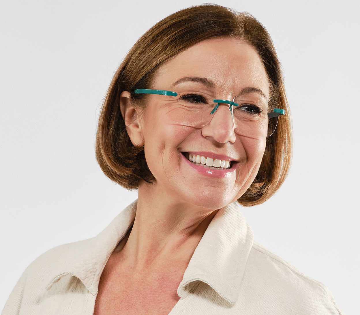 Female model wearing Jelli Max (Turquoise) square, rimless reading glasses with large lenses and turquoise details.