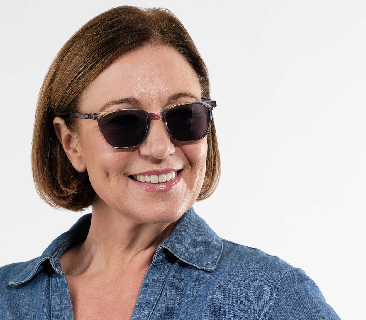 Female model wearing Saffron (Multi-coloured) multicoloured women's sunglasses with delicate floral details. Large, grey tinted oval lenses.