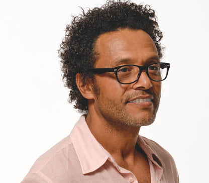 Male model wearing Harper (Black) retro, unisex reading glasses with oval lenses and glossy black frames.