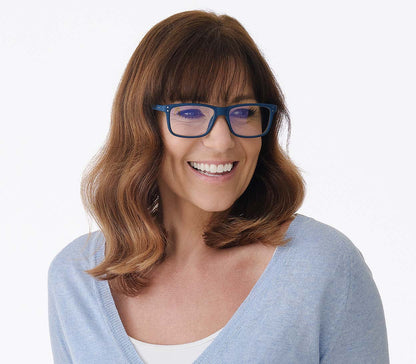 Female model wearing Austin (Blue) classic shaped, unisex blue light glasses. Deep blue frames with soft touch finish and rivet details.