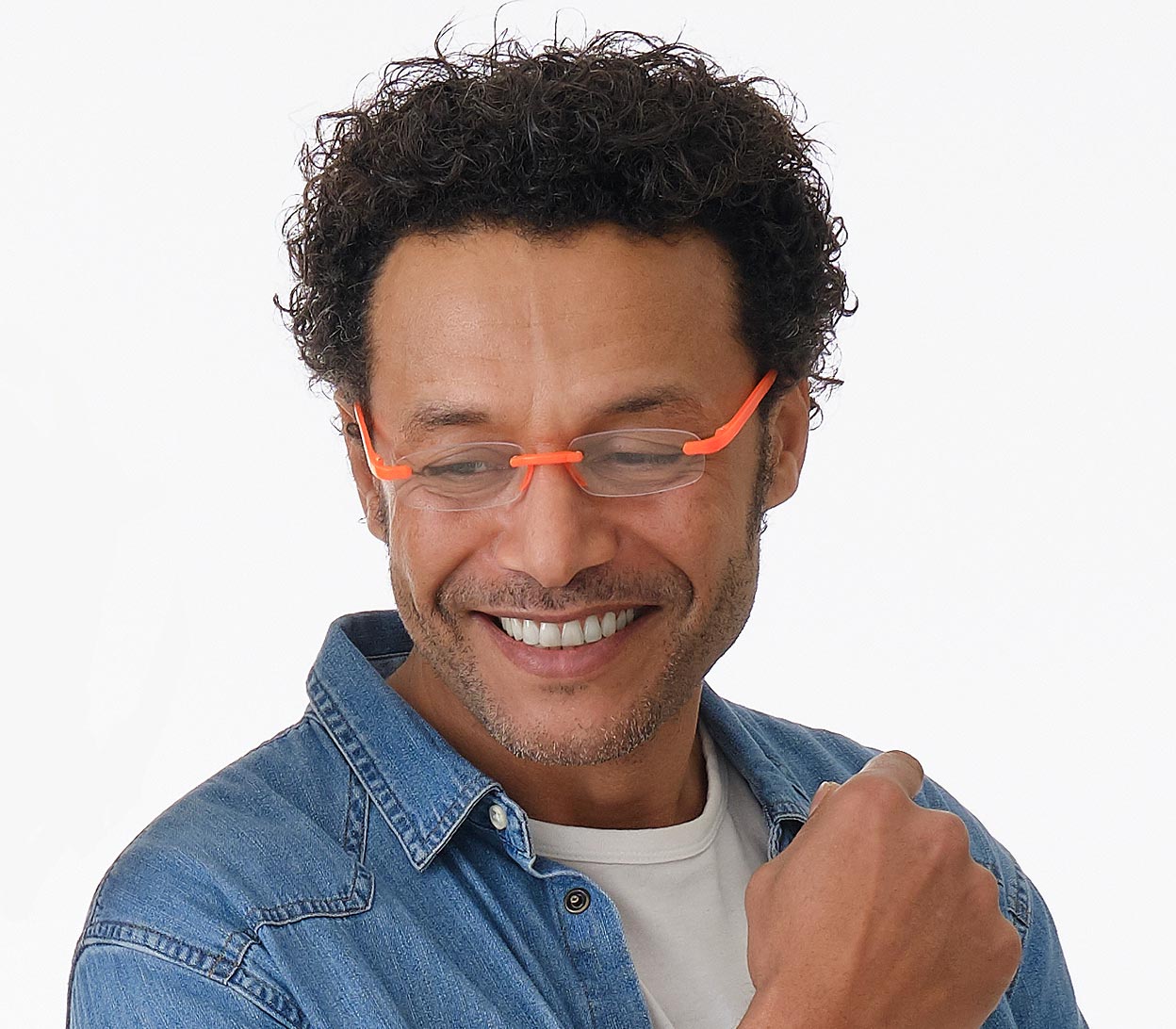 Male model wearing Jelli Neon (Orange) rimless, slim reading glasses with semi-translucent bright orange temples and bridge.
