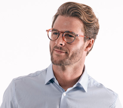 Male model wearing Oskar (Multi-coloured) unisex reading glasses with large round lenses and a glossy multi-coloured frame.