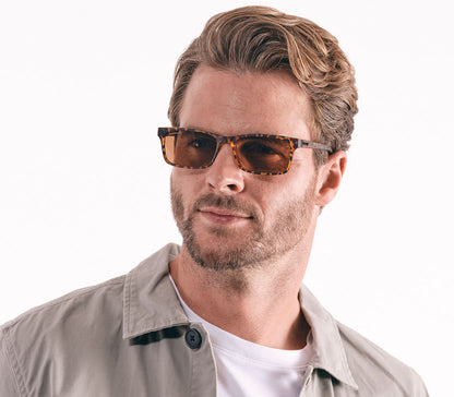 Male model wearing Sunlight (Tortoiseshell) classic unisex reading glasses with rectangular brown tinted lenses and a bold tortoiseshell frame.