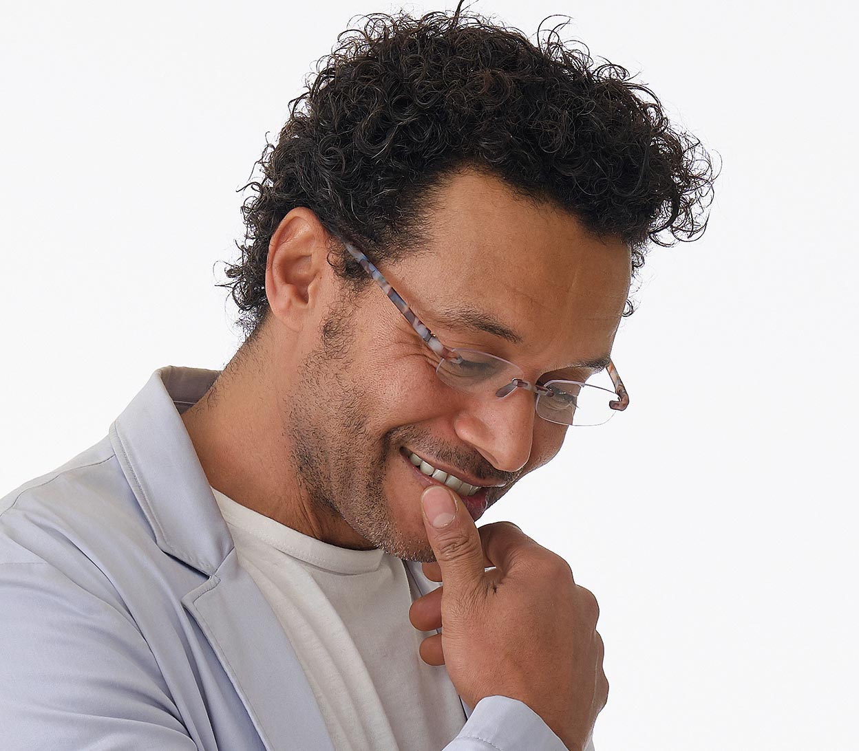 Male model wearing Jelli (Multi Tortoise) rimless, slim reading glasses with semi translucent, tortoiseshell arms and bridge.