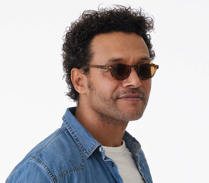 Male model wearing Montpellier (Tortoiseshell) retro style sunglasses in a rich tortoiseshell finish. Round, brown tinted lenses.