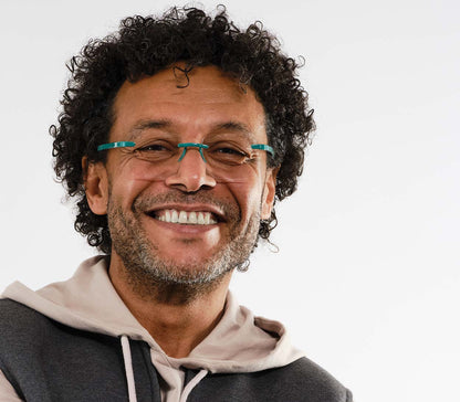 Male model wearing Jelli Max (Turquoise) square, rimless reading glasses with large lenses and turquoise details.