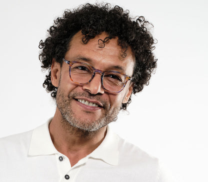 Male model wearing Scholar (Multi-coloured) retro unisex reading glasses with large oval shaped lenses, slender patterned multi-coloured frame.